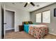 Cozy bedroom featuring a ceiling fan, two windows, and a comfortable bed at 680 Moonlight Stroll St, Henderson, NV 89002