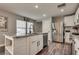 Charming kitchen with an island, stainless steel refrigerator, and hardwood floors at 680 Moonlight Stroll St, Henderson, NV 89002