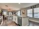 Open kitchen view showcasing granite countertops, a kitchen island, stainless steel appliances and hardwood floors at 680 Moonlight Stroll St, Henderson, NV 89002