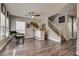 Inviting living room with wood flooring, a ceiling fan, and a staircase at 680 Moonlight Stroll St, Henderson, NV 89002