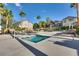 Community pool with lounge chairs, palm trees, and nearby homes in a sunny setting at 680 Moonlight Stroll St, Henderson, NV 89002