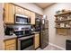 Bright kitchen features stainless steel appliances, wood cabinets, and granite countertops at 6955 N Durango Dr # 2081, Las Vegas, NV 89149