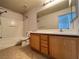 This bright bathroom has a tub-shower combo, a large mirror, and wood-look cabinets at 7249 Old Glory St, Las Vegas, NV 89148