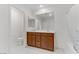 Double vanity bathroom with wood cabinetry, modern fixtures, and shower with patterned curtain at 7256 Saxby Ave, Las Vegas, NV 89113