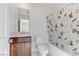 This bathroom features a toilet, printed shower curtain, and a wood vanity with a sink and mirror at 7256 Saxby Ave, Las Vegas, NV 89113