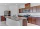 Modern kitchen with stainless steel appliances, granite countertops, and a central island with a sink at 7256 Saxby Ave, Las Vegas, NV 89113