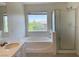The bathroom boasts a soaking tub, vanity with sink, and glass-enclosed shower at 740 White Grotto St, Las Vegas, NV 89138