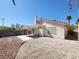 Exterior view of home and covered patio in a low maintenance backyard featuring desert landscaping at 7614 Isley Ave, Las Vegas, NV 89147