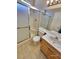 Bright bathroom featuring tiled floors, a shower with glass doors, and a wooden vanity at 7614 Isley Ave, Las Vegas, NV 89147