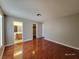 Bedroom with hardwood floors, neutral paint, and access to the bathroom and closet areas at 7614 Isley Ave, Las Vegas, NV 89147
