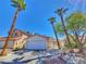 Charming single-story home with a well-manicured yard and mature palm trees under a bright blue sky at 7614 Isley Ave, Las Vegas, NV 89147