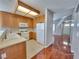 Bright kitchen featuring wood cabinets, white appliances, and tile flooring, seamlessly connected to the entryway at 7614 Isley Ave, Las Vegas, NV 89147