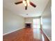 Cozy living room featuring a fireplace, sliding glass doors, wood flooring, and a ceiling fan at 7614 Isley Ave, Las Vegas, NV 89147
