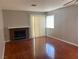 Sunlit living room featuring a fireplace, wood flooring, and large windows with modern blinds at 7614 Isley Ave, Las Vegas, NV 89147