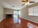 Living room with a fireplace, ceiling fan, sliding glass doors, and wood flooring at 7614 Isley Ave, Las Vegas, NV 89147