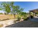 Lush backyard features desert landscaping, a covered patio, and views of the manicured golf course at 7649 Broadwing Dr, North Las Vegas, NV 89084