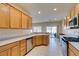 Bright kitchen features stainless appliances, natural wood cabinets, and sliding glass doors to the backyard at 7649 Broadwing Dr, North Las Vegas, NV 89084