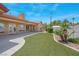 Manicured backyard with large artificial turf and covered patio at 7668 Friendly Breeze Ct, Las Vegas, NV 89123