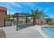Backyard features an outdoor gazebo, desert landscaping, a pool with a Baja shelf, and a concrete patio at 7668 Friendly Breeze Ct, Las Vegas, NV 89123