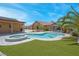 Backyard features a swimming pool with a spa, mature trees, a covered gazebo, and desert landscaping at 7668 Friendly Breeze Ct, Las Vegas, NV 89123