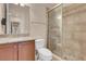 Well-lit bathroom featuring granite counters, a glass shower, and neutral tile flooring at 7668 Friendly Breeze Ct, Las Vegas, NV 89123