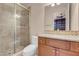 Bathroom featuring a glass-enclosed shower with neutral tile, a granite-topped vanity with wood cabinets and a neutral color scheme at 7668 Friendly Breeze Ct, Las Vegas, NV 89123