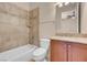 Well-lit bathroom featuring neutral tile, tub, and sink with vanity, creating a relaxing retreat at 7668 Friendly Breeze Ct, Las Vegas, NV 89123