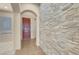 Inviting entryway featuring a stone accent wall and a wooden front door at 7668 Friendly Breeze Ct, Las Vegas, NV 89123