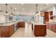 Gourmet kitchen featuring granite countertops, pendant lighting, stainless appliances, and custom cabinetry at 7668 Friendly Breeze Ct, Las Vegas, NV 89123