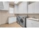 Laundry room boasts modern appliances, ample cabinetry, granite countertops, and tile floors for convenient chores at 7668 Friendly Breeze Ct, Las Vegas, NV 89123
