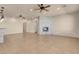 Spacious living room with fireplace, neutral decor, ceiling fan, and tile floors at 7668 Friendly Breeze Ct, Las Vegas, NV 89123