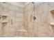 Walk-in shower with neutral tile, corner seat, and updated fixtures at 7668 Friendly Breeze Ct, Las Vegas, NV 89123