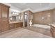 Elegant bathroom featuring marble walls, double sink vanity, soaking tub, and glass shower at 807 Canyon Greens Dr, Las Vegas, NV 89144