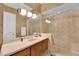 Luxurious bathroom featuring a glass-enclosed shower, marble countertops, and decorative wallpaper at 807 Canyon Greens Dr, Las Vegas, NV 89144