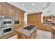 Gourmet kitchen featuring stainless steel appliances, wooden cabinets, and a granite-topped kitchen island at 807 Canyon Greens Dr, Las Vegas, NV 89144