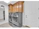 Modern laundry room with high-end washer and dryer set and ample cabinet storage space at 807 Canyon Greens Dr, Las Vegas, NV 89144