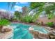 Inviting pool and spa surrounded by lush landscaping, creating a private backyard oasis at 807 Canyon Greens Dr, Las Vegas, NV 89144