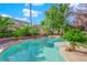 Inviting backyard pool and spa surrounded by palm trees and tropical foliage at 807 Canyon Greens Dr, Las Vegas, NV 89144