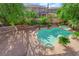 Backyard view of a sparkling pool, jacuzzi, and lush green landscaping at 807 Canyon Greens Dr, Las Vegas, NV 89144