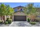 Inviting two-story home with a well-manicured lawn and a two-car garage, embraced by mature trees at 8739 Cerrito Canyon Ct, Las Vegas, NV 89148