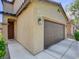 Exterior view of a two car garage with beige stucco and a dark brown garage door at 8739 Cerrito Canyon Ct, Las Vegas, NV 89148