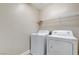 Practical laundry room featuring a washer, dryer, and shelving for storage at 8739 Cerrito Canyon Ct, Las Vegas, NV 89148