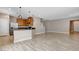 Open-concept living area with wood-look floors, a kitchen island, and neutral paint at 8739 Cerrito Canyon Ct, Las Vegas, NV 89148
