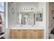 Bright bathroom features double sinks with maple cabinetry, and a large mirror and vanity lighting at 8801 Duncan Barrel Ave # 103, Las Vegas, NV 89178