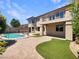 Beautiful backyard featuring turf and a sparkling in-ground pool and spa at 9319 Bronze River Ave, Las Vegas, NV 89149