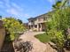 Lush backyard with manicured landscaping, covered patio, and exterior of home at 9319 Bronze River Ave, Las Vegas, NV 89149