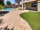 Large backyard featuring a pool, stone pavers, turf, and the exterior of the home at 9319 Bronze River Ave, Las Vegas, NV 89149
