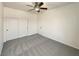 Bedroom with neutral carpet, ceiling fan, and closet with doors at 9319 Bronze River Ave, Las Vegas, NV 89149