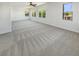 Spacious living room with neutral carpet, large windows and ceiling fan at 9319 Bronze River Ave, Las Vegas, NV 89149