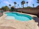Backyard swimming pool with palm trees, concrete patio, and privacy wall at 9319 Bronze River Ave, Las Vegas, NV 89149